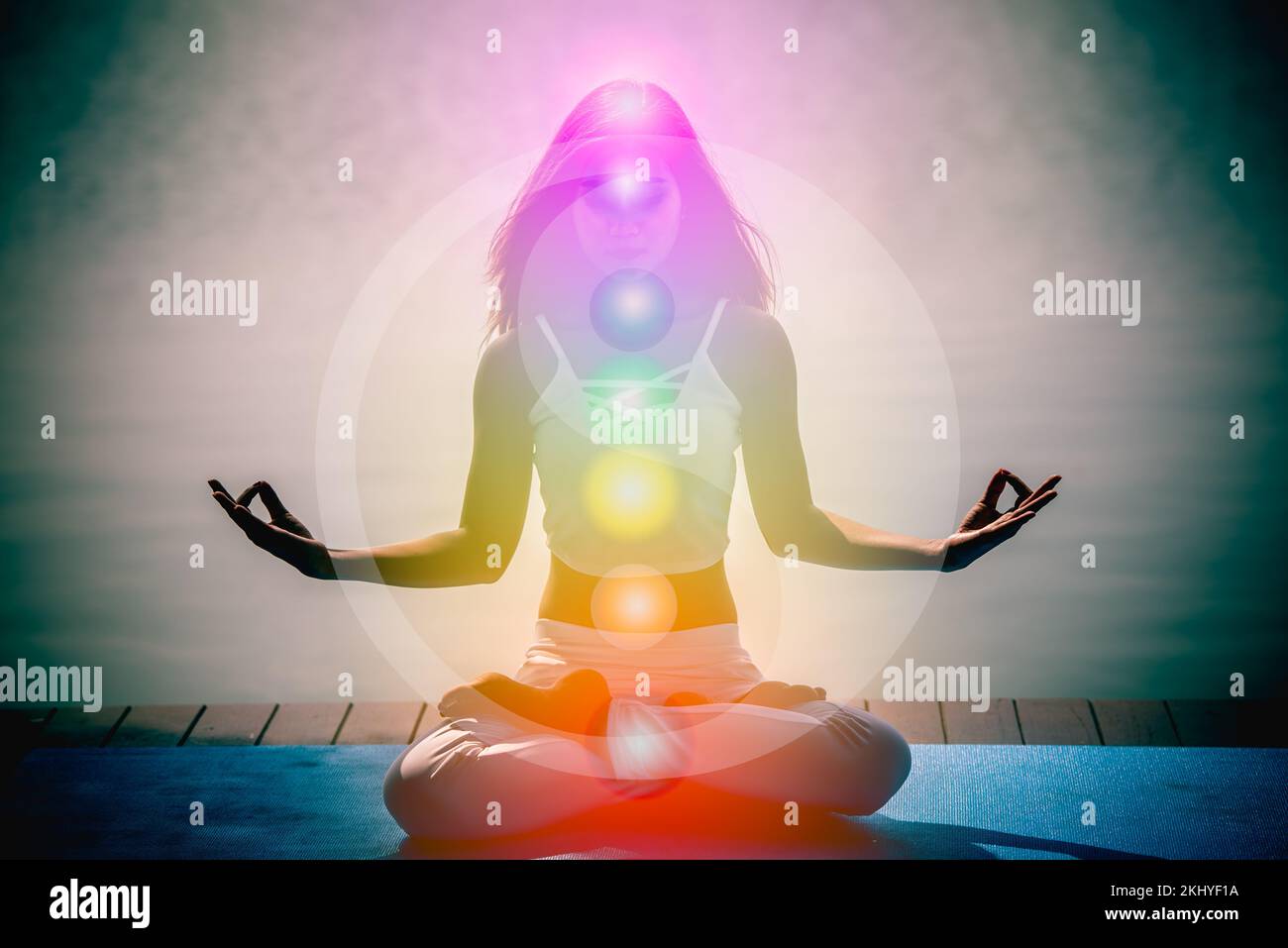 Junge Aura-Frau in Yoga-Meditation mit der Natur, sieben Chakren und Yin Yang-Symbolen. Stockfoto