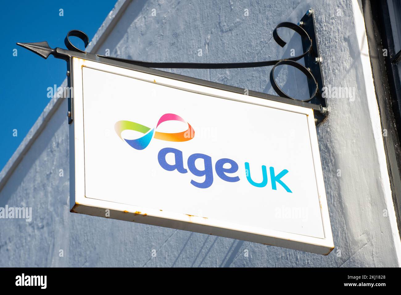 Age UK-Logo auf dem Schild vor einem Wohltätigkeitsladen, England, Großbritannien Stockfoto