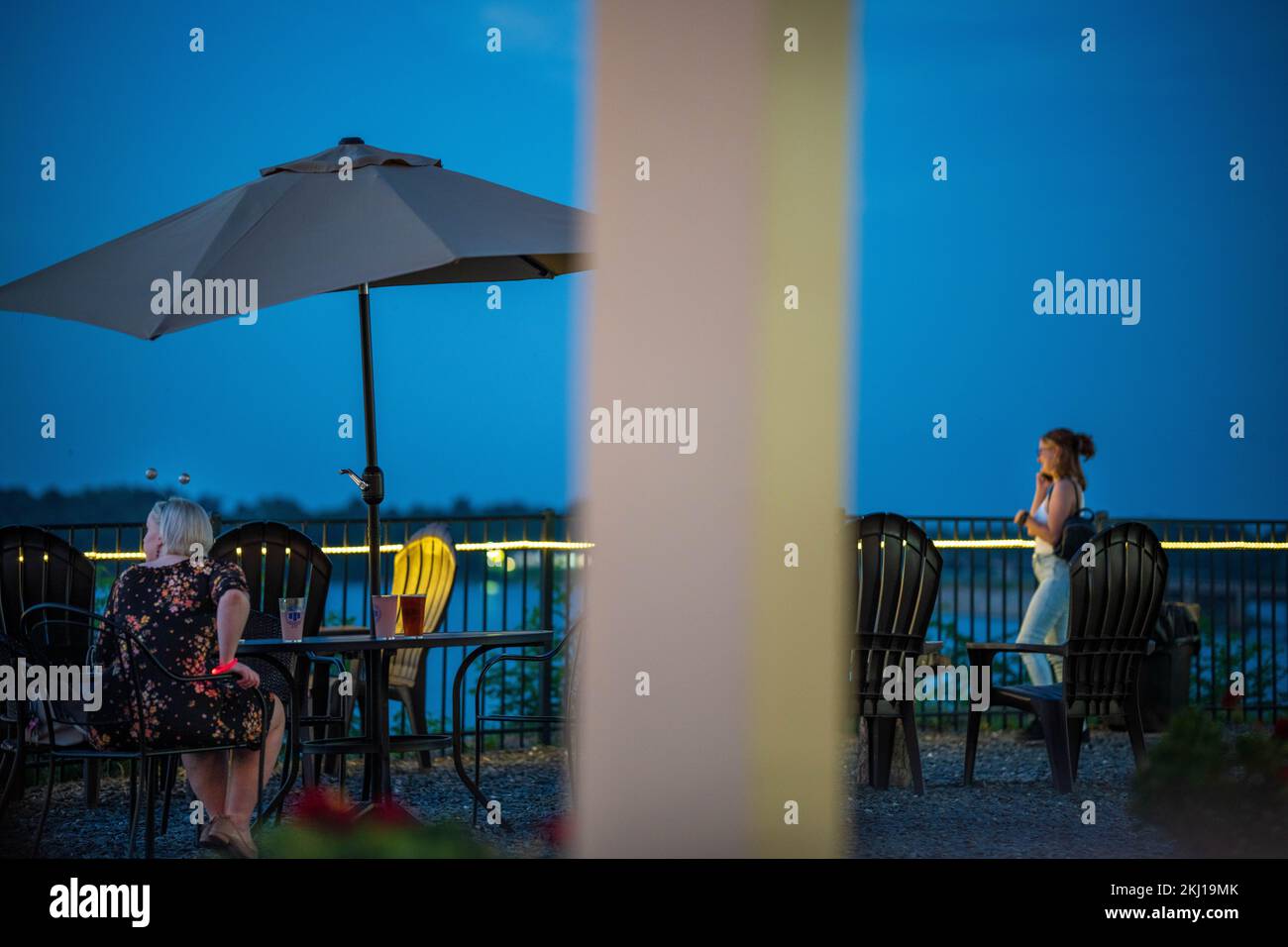 Mädchen auf der Terrasse am Abend am See Stockfoto
