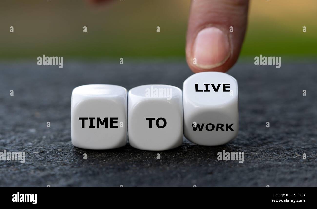 Die Hand würfelt und ändert den Ausdruck „Arbeitszeit“ in „Lebenszeit“. Stockfoto