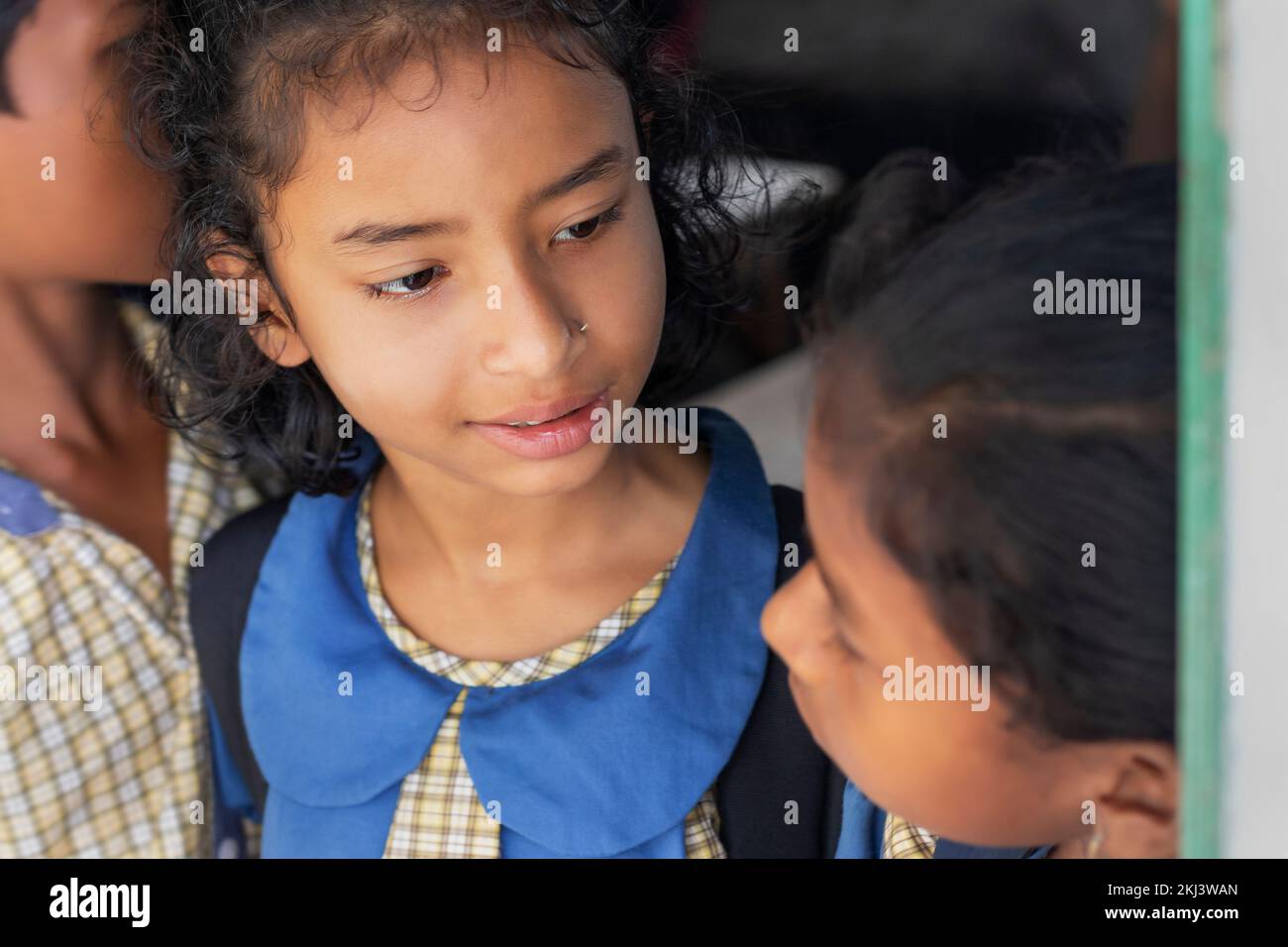 Schülerinnen, die sich mit Freunden in der Schule unterhalten Stockfoto