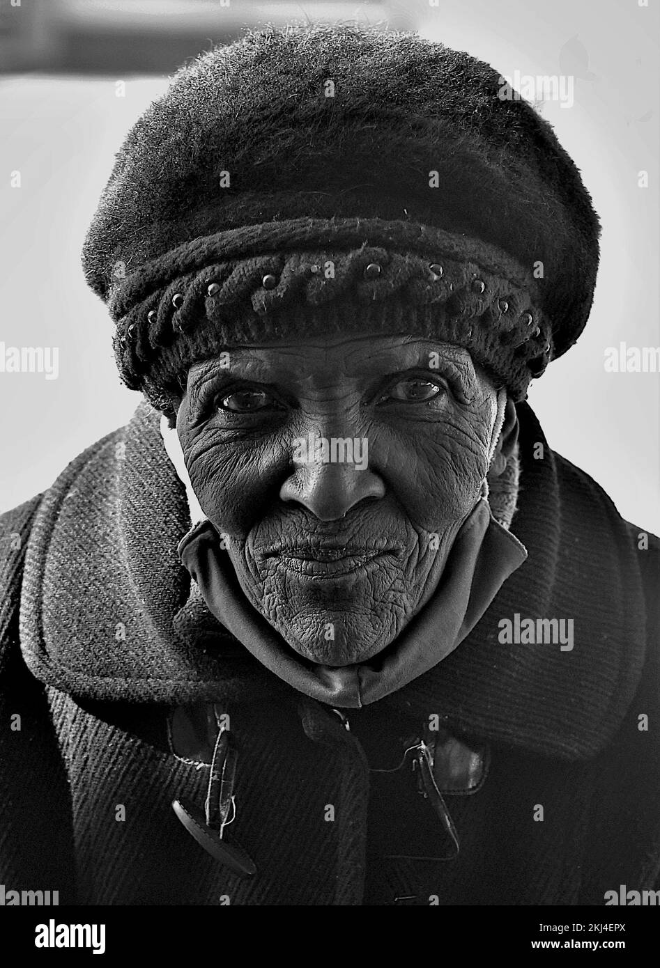 Ein Schwarzweißfoto einer alten Afrikanerin mit faltigem Gesicht Stockfoto