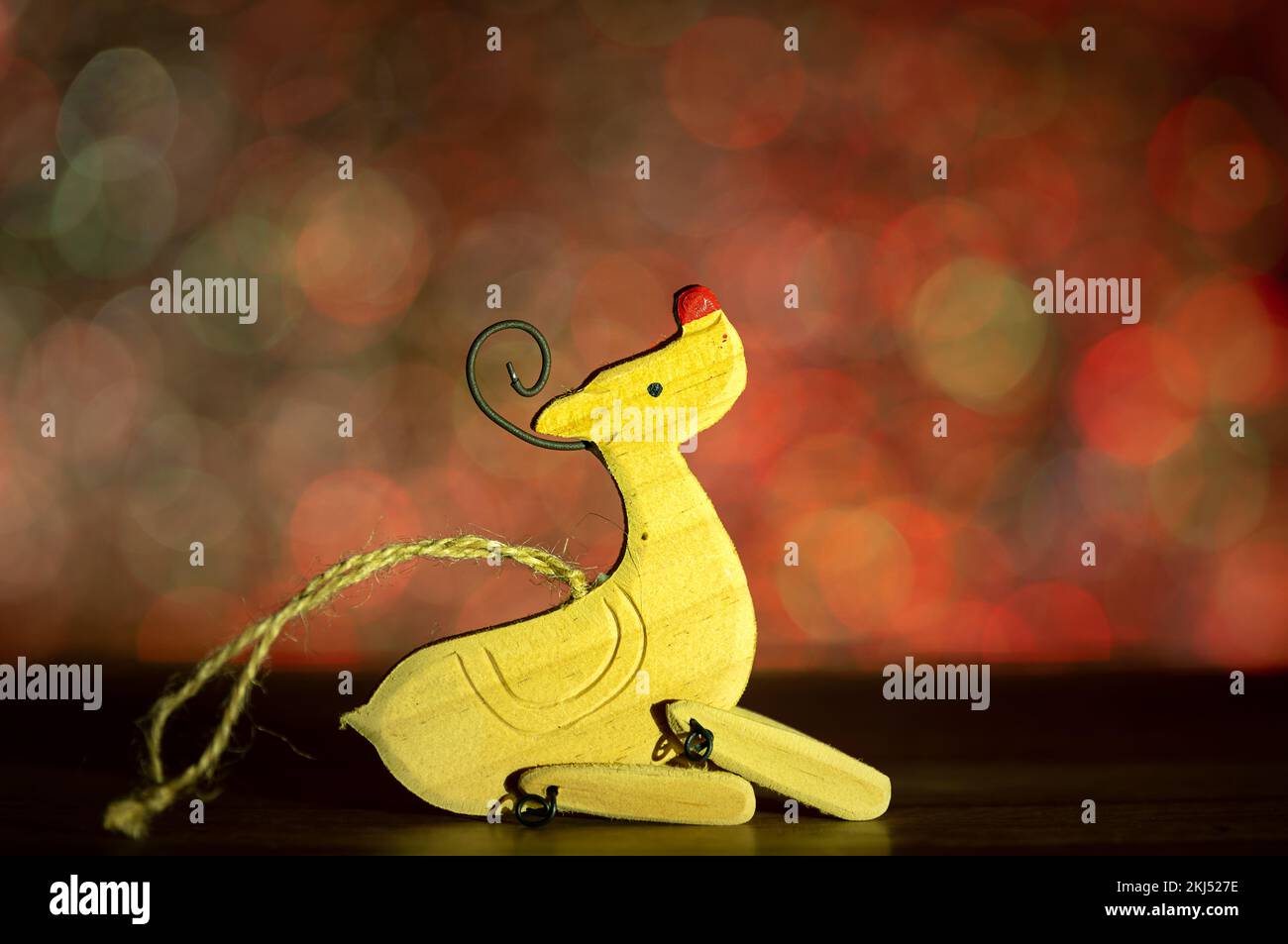 weihnachtsdekoration mit Holzrentieren vor der farbenfrohen El-Bokeh-Wand. Stockfoto