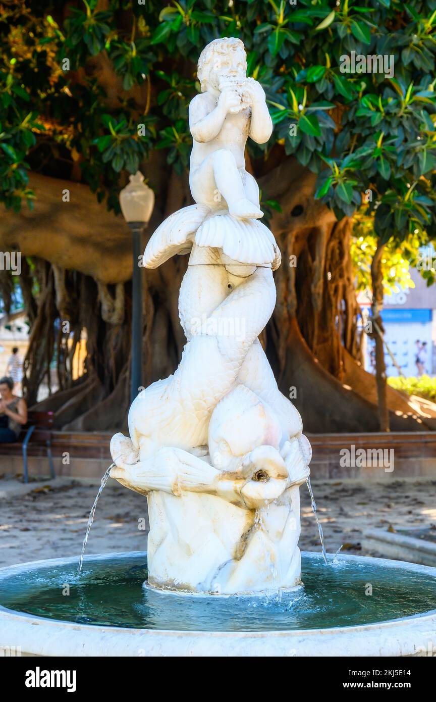 Alicante, Spanien - 12. September 2022: Ein kleiner Brunnen mit einer Skulptur im Canalejas Park. Die Skulptur besteht aus einem Flötisten, der auf dem Schwanz sitzt Stockfoto