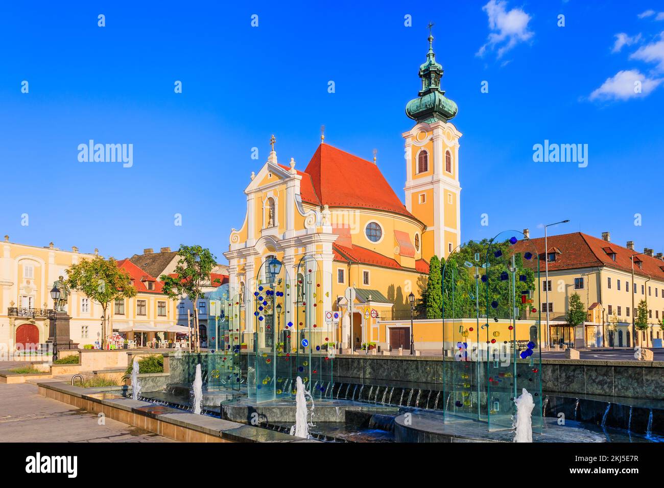 Gyor, Ungarn. Karmelitenkirche und Wasserbrunnen. Stockfoto