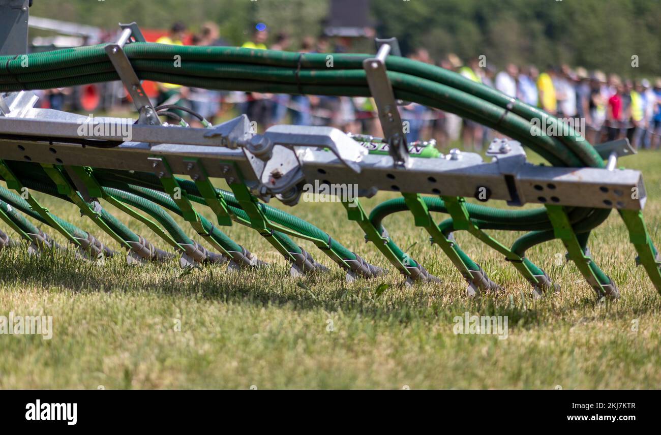 Weidenbach, Deutschland. 19.. Mai 2022. Ein Traktor zieht während einer Demonstration am Gülletag einen Gülletanker mit Schleppschuhausleger für die Gülleausbringung nahe am Boden. Der Landwirtschaftliche Lehranstalten Triesdorf stellte an einem Gülletag die neuesten Gülleausbringungstechniken vor. Kredit: Daniel Karmann/dpa/Alamy Live News Stockfoto