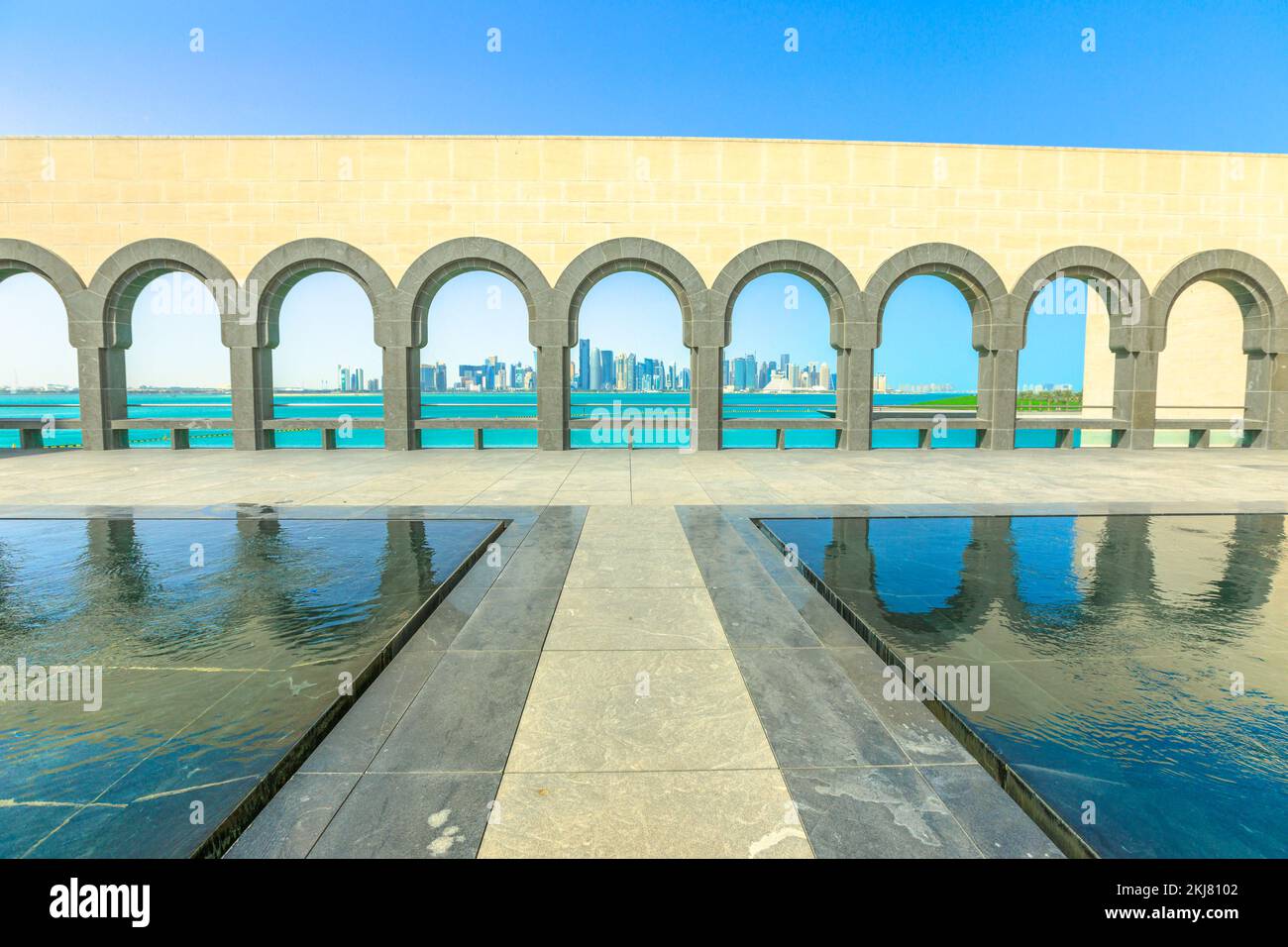 Doha, Katar - 16. Februar 2019: Blick auf den Bogengang und die reflektierenden Pools im Museum of Islamic Art oder MIA. Doha West Bay und Persischer Golf weiter Stockfoto