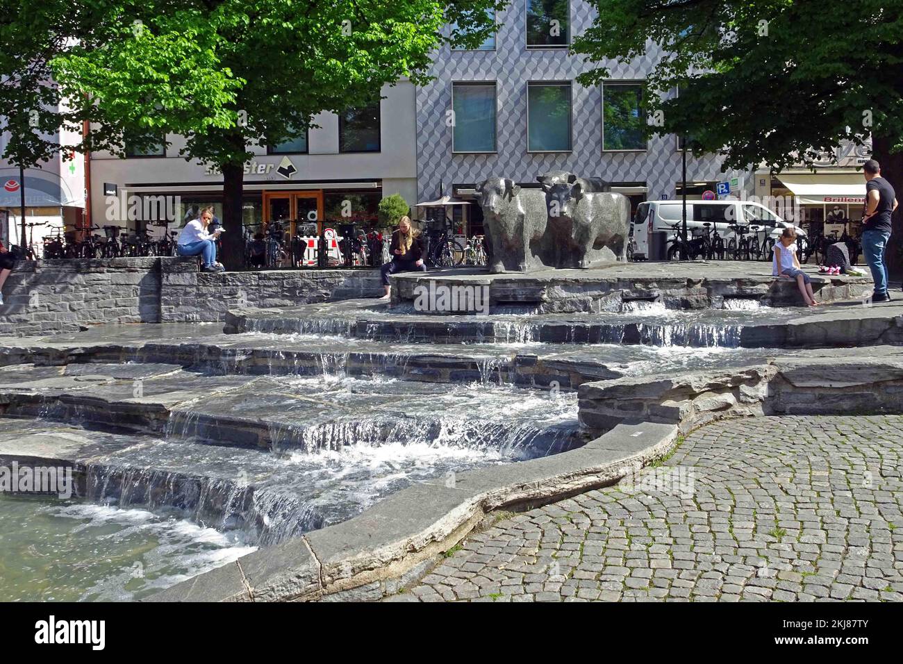Deutschland, Bayern, München: Der Rindermarkt, früher der Rindermarkt der Stadt, mit seinem terrassenförmigen Brunnen und Bronzerindern. Stockfoto