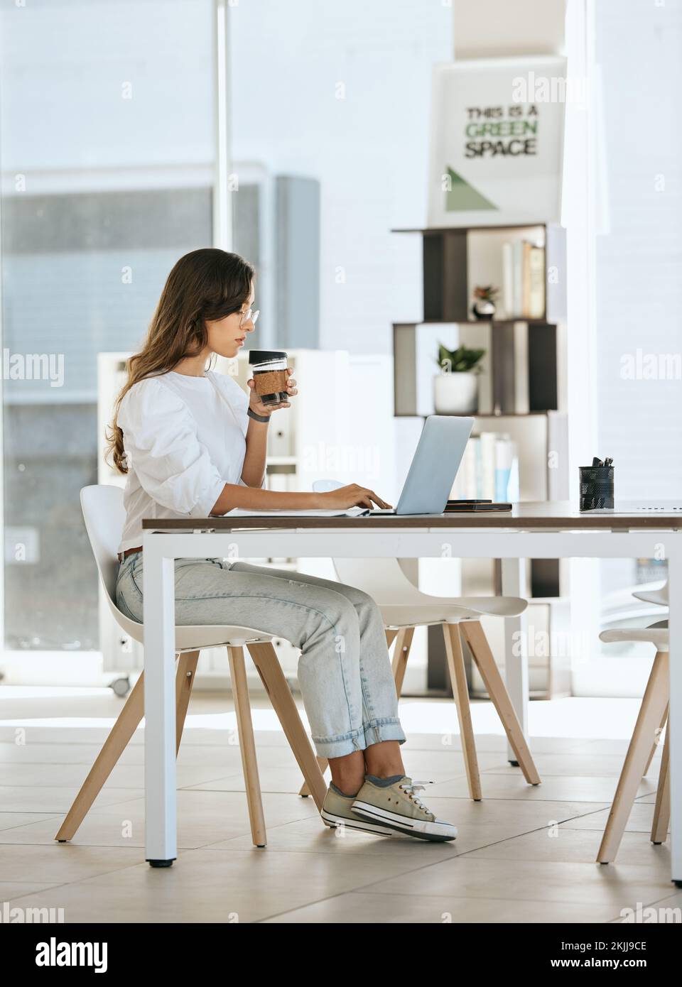 Laptop, Kaffee und Geschäftsfrau im Büro, die Espresso oder Cappuccino trinkt. Computer, Tee und Frau aus Kanada mit heißem Getränk beim Tippen Stockfoto