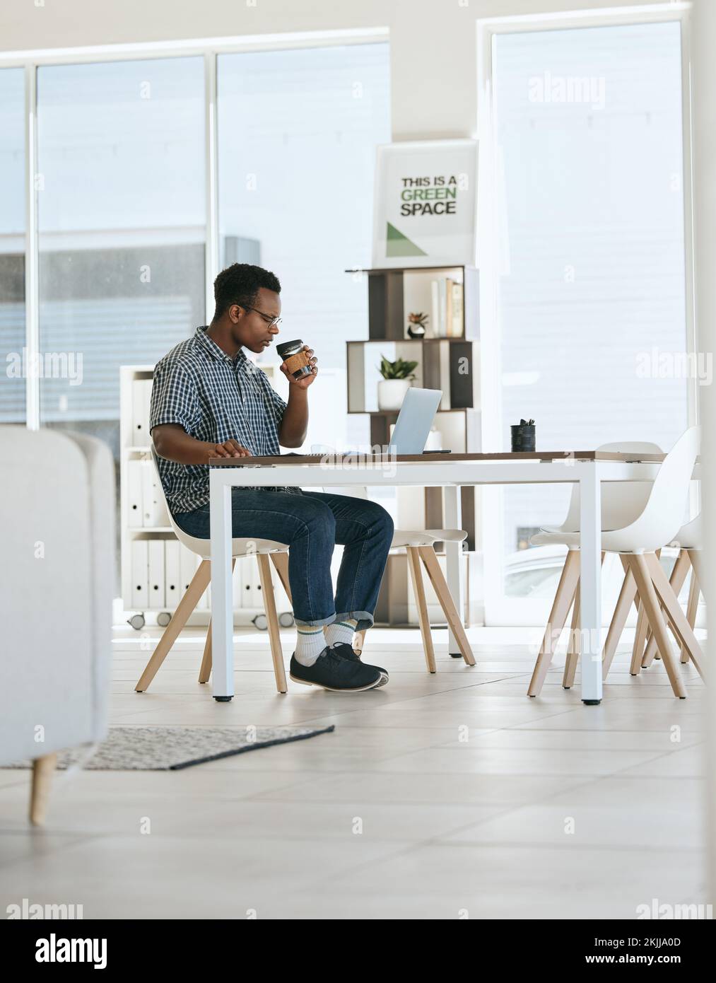 Schwarzer Mann, Kaffeetrinken und Büro mit Laptop, Tisch und Denkweise in Marketing-Startup-Unternehmen. Mann, trinken Sie Espresso oder Tee am Schreibtisch mit Computer Stockfoto
