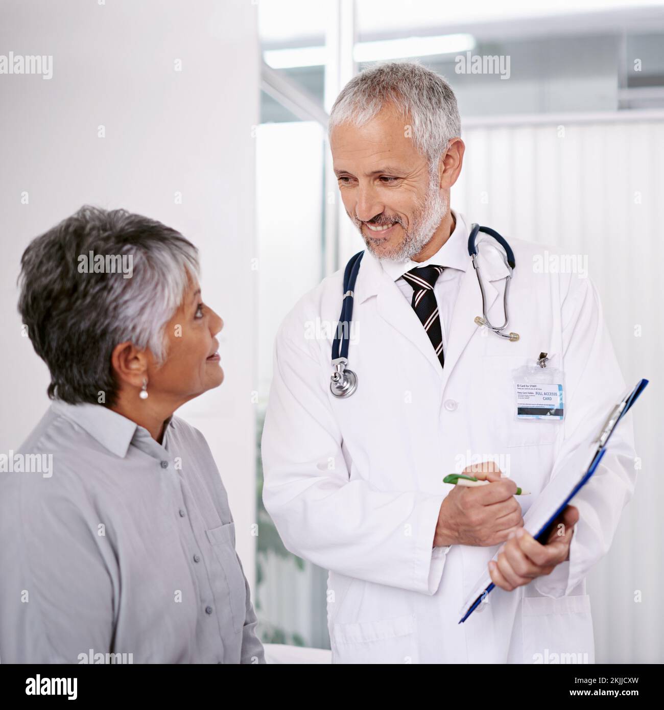Durchlaufen eines Bestrahlungsplans mit seinem Patienten. Ein Arzt, der mit einem Patienten in einer Klinik spricht. Stockfoto