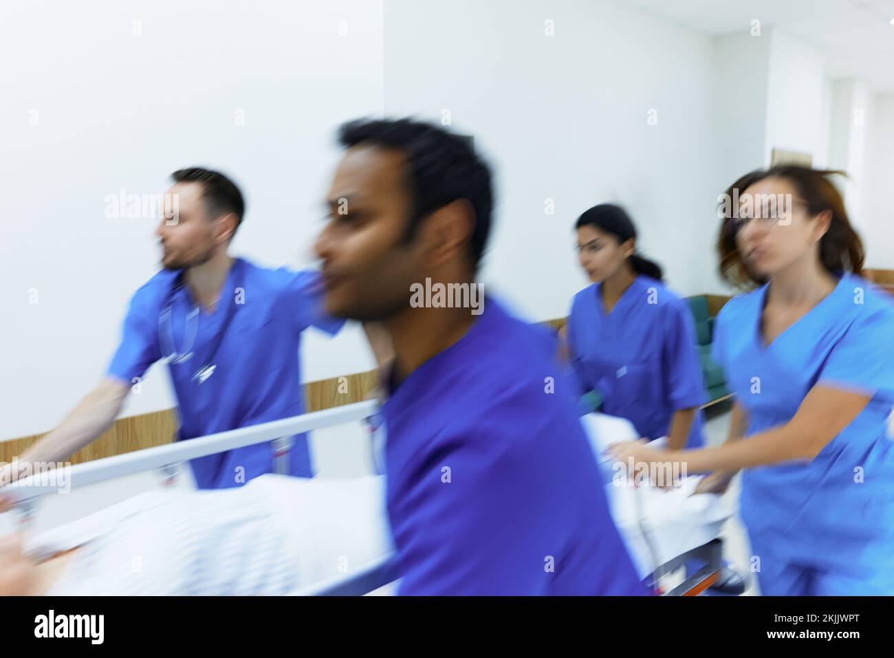 Bewegungsunschärfe-Effekt im Krankenhausnotfall mit Patient auf Trage und medizinischem Personal, das ihn schiebt. Die Arbeit des Notfallteams Stockfoto