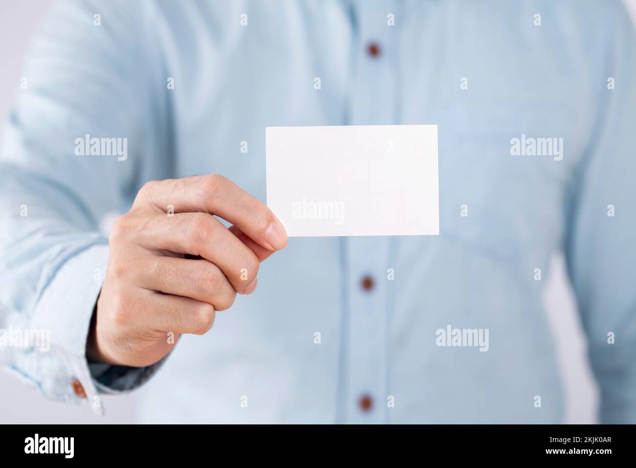 Unternehmer, die eine leere Visitenkarte auf weißen Hintergrund Stockfoto