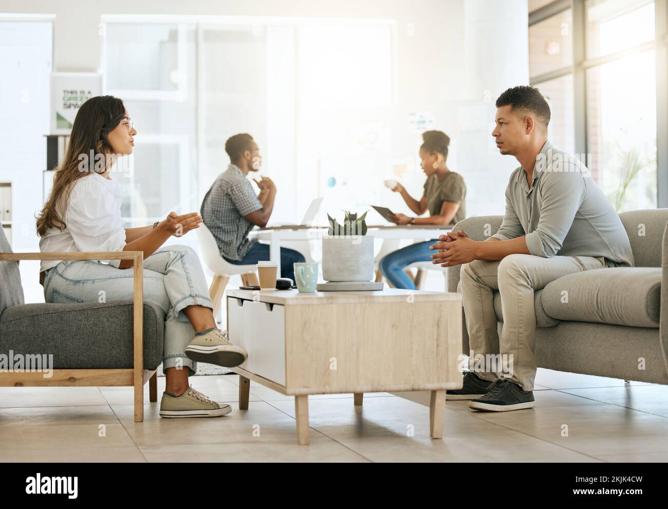 Geschäftsleute, Bürodiskussionen und Marketing-Team auf dem Sofa in einer Werbeagentur für Meetings, Zusammenarbeit und Planung. Designarbeiter, die miteinander reden Stockfoto