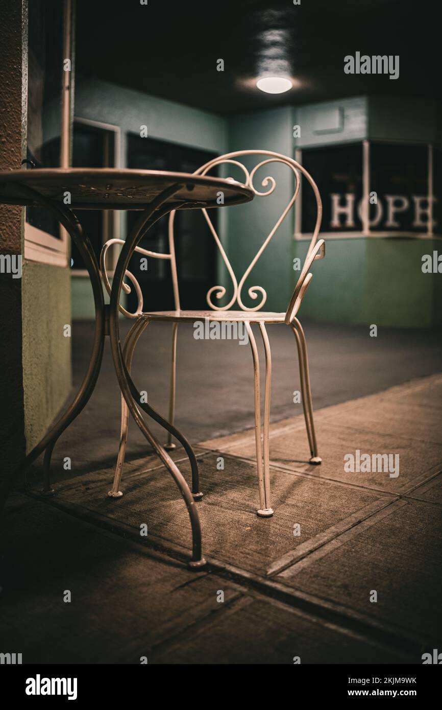 Eine vertikale Aufnahme eines wunderschönen dekorativen Metalltisches und -Stuhls im Vintage-Stil Stockfoto