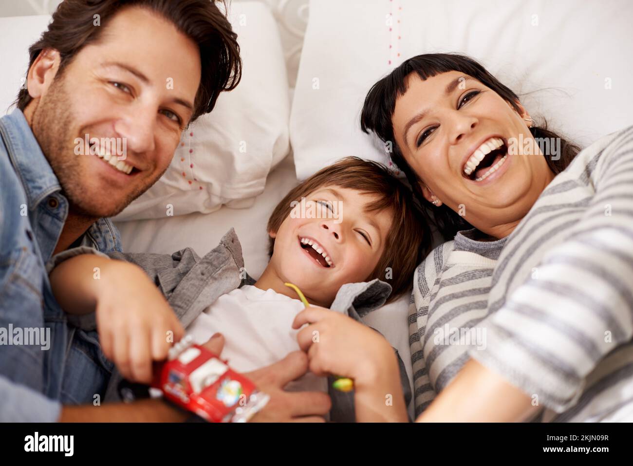 Zuhause ist, wo das Lachen ist. Porträt glücklicher Eltern, die sich zu Hause mit ihrem Sohn verbinden. Stockfoto