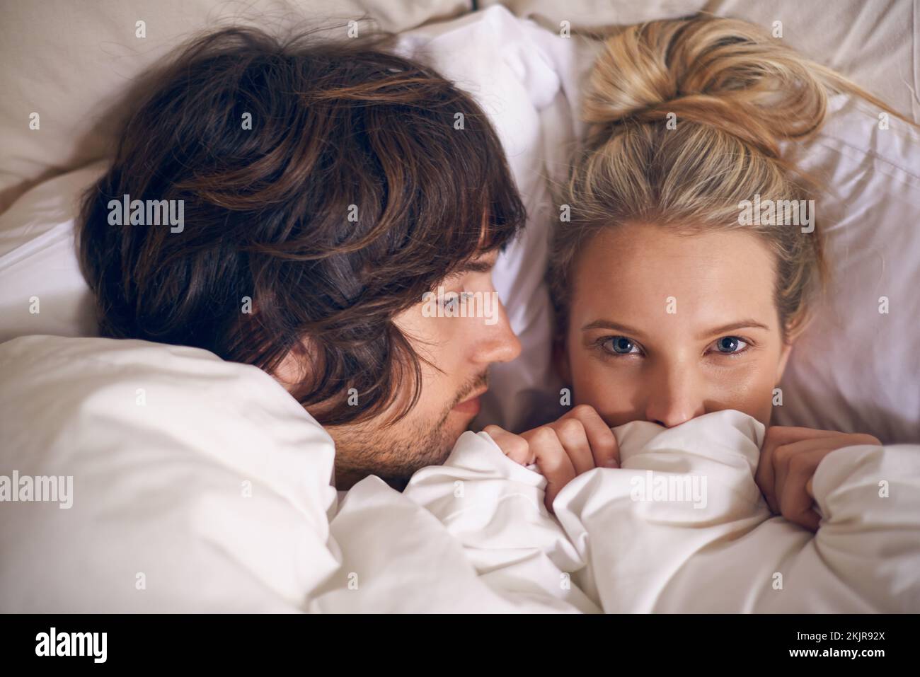 Undercover-Liebhaber. Ein liebevolles junges Paar, das sich unter der Decke entspannt. Stockfoto