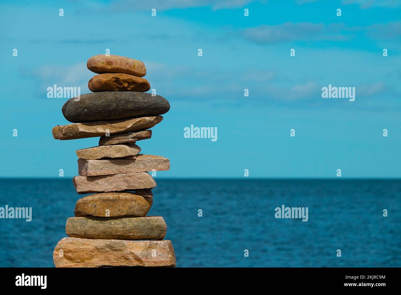 Ein Steinstapel. Steinturm mit Meeresunschärfe im Hintergrund Stockfoto