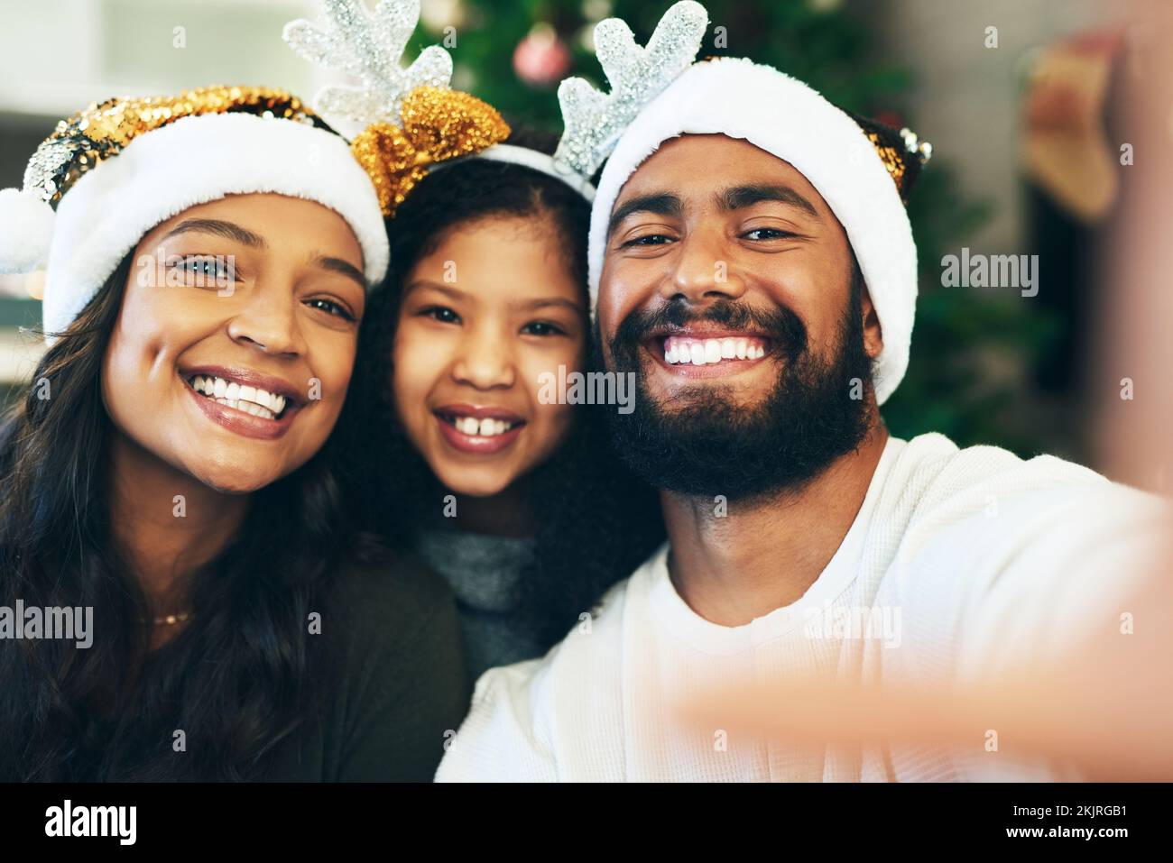 Familie, Weihnachtsselfie und Feiertagsfeier, Porträt und Gesicht zu Hause, Hut und Dekoration zusammen. Mutter, Vater und Mädchen mit Bild Stockfoto