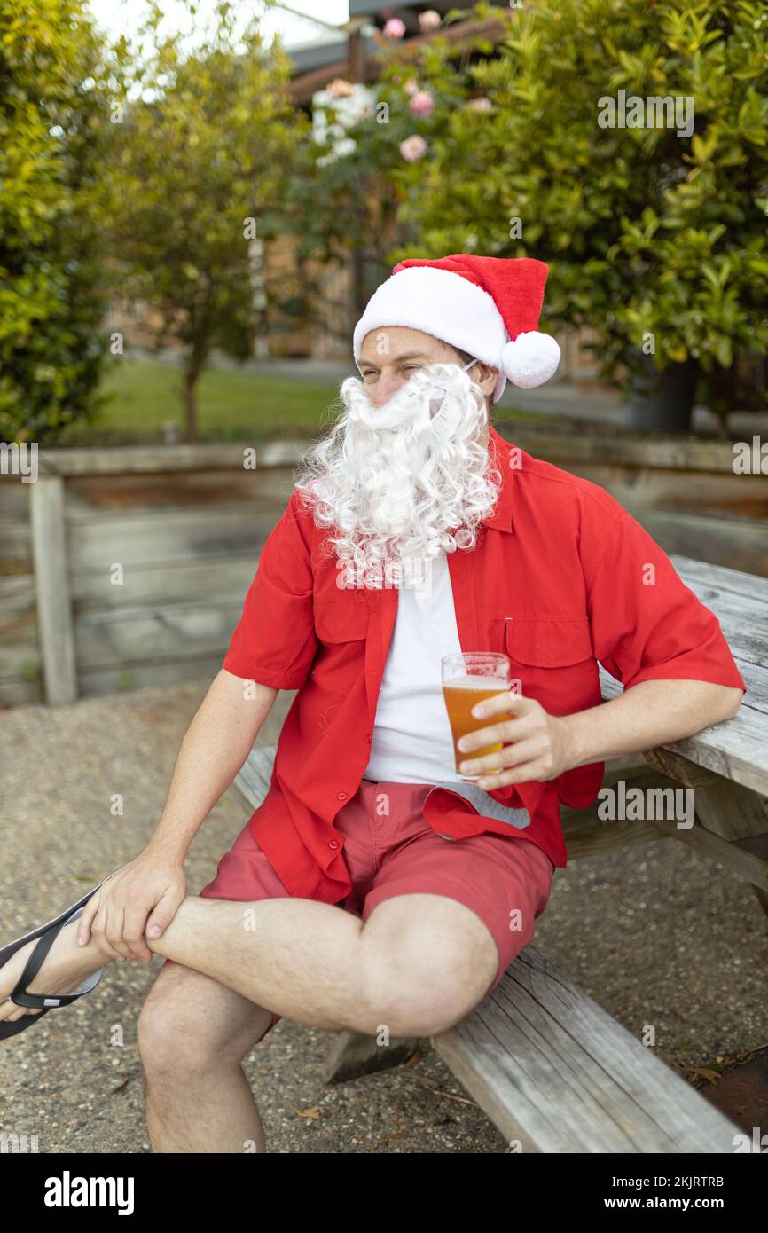 Ein Weihnachtsmann zu Weihnachten im australischen Sommer mit einem Bier Stockfoto