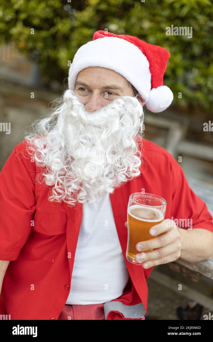 Ein Weihnachtsmann zu Weihnachten im australischen Sommer mit einem Bier Stockfoto