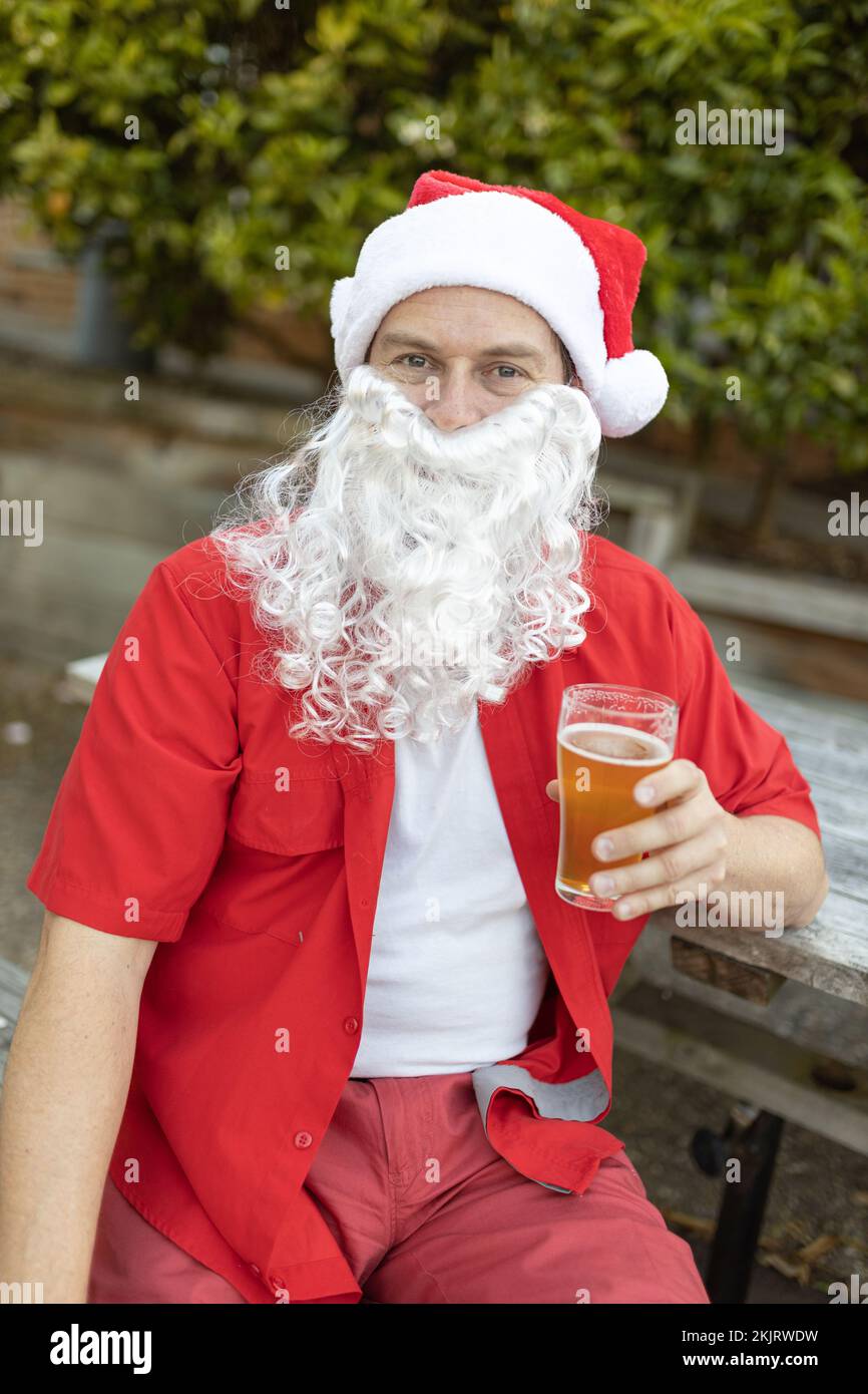 Ein Weihnachtsmann zu Weihnachten im australischen Sommer mit einem Bier Stockfoto