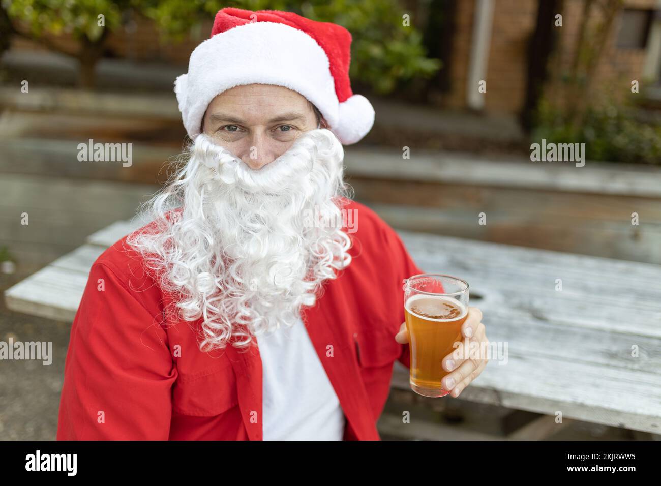 Ein Weihnachtsmann zu Weihnachten im australischen Sommer mit einem Bier Stockfoto