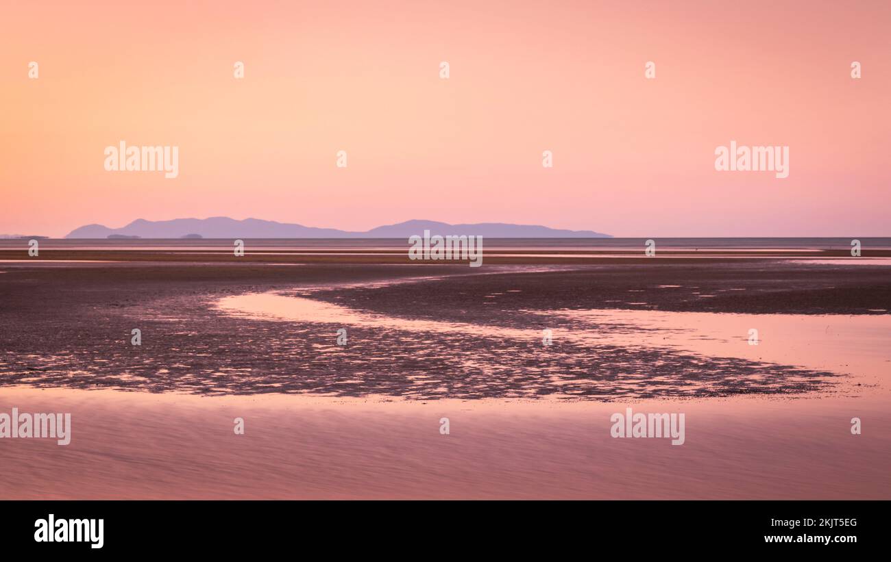 Pinke Abenddämmerung am Buschlandstrand in townsville, queensland Stockfoto