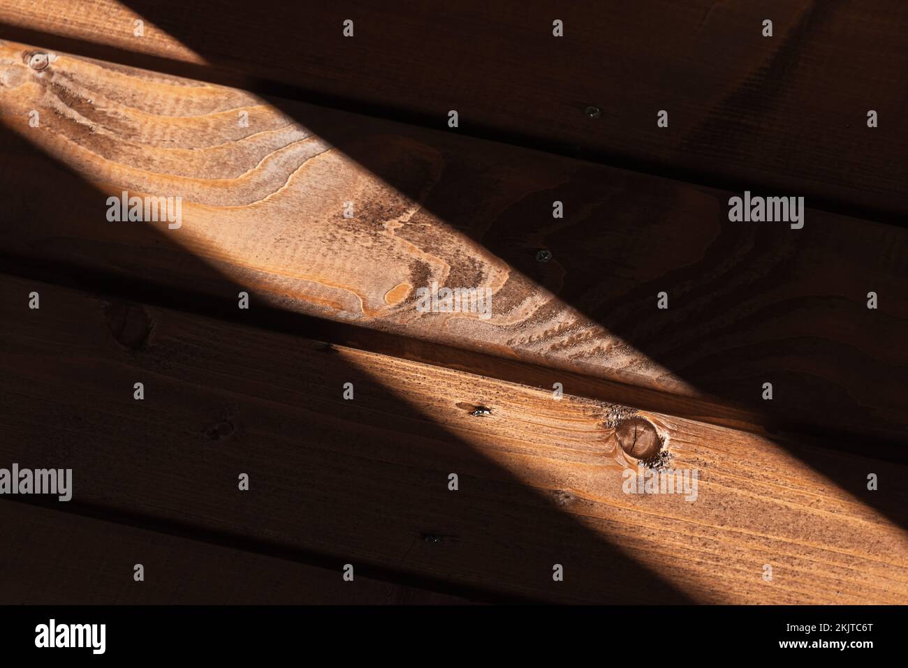 Dunkle Holzwand mit Lichtstrahl, abstrakte Fotostruktur im Hintergrund Stockfoto
