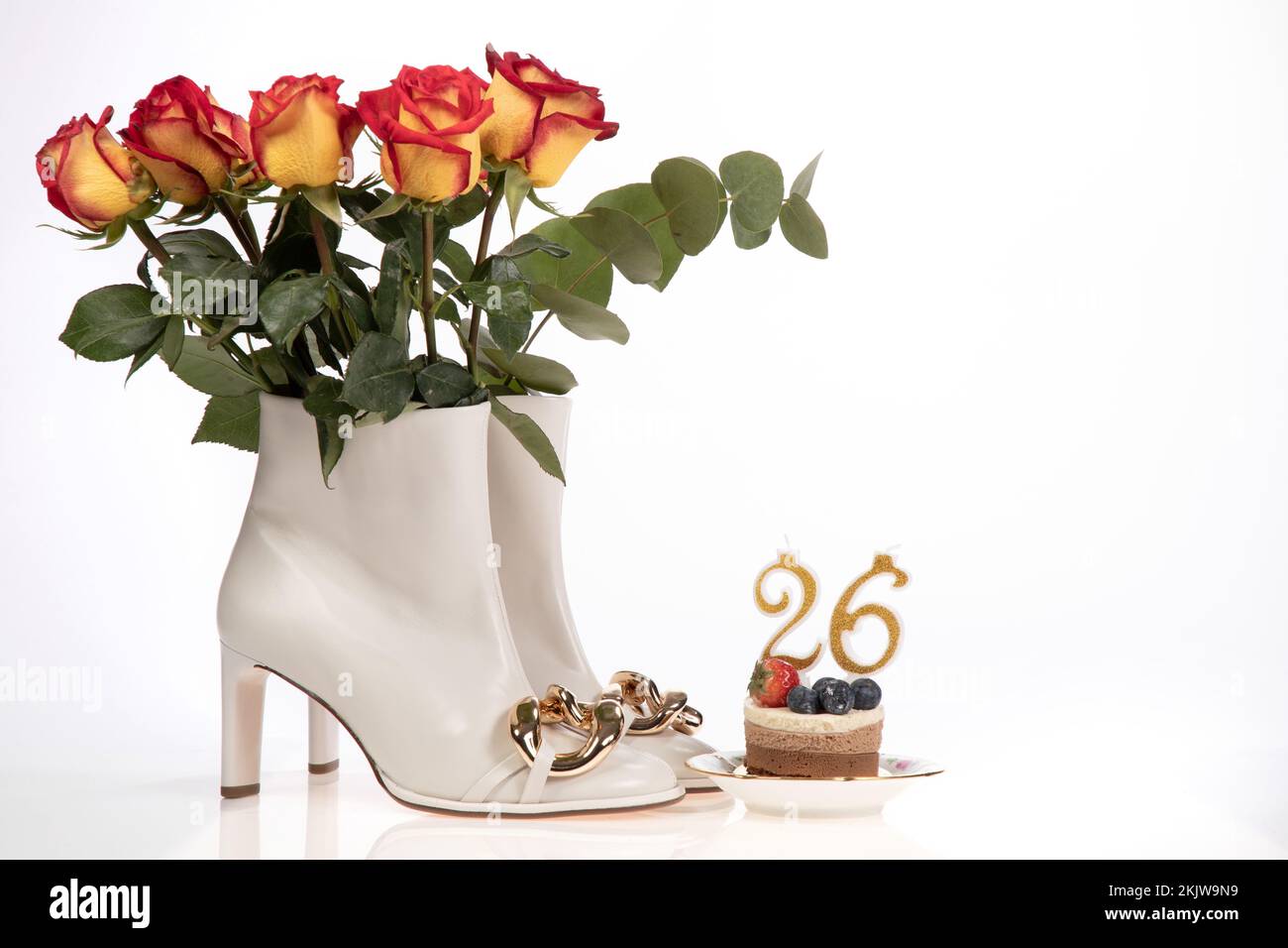 Geburtstagskarte mit Kuchen Damenstiefeln und Rosen auf weißem Hintergrund Stockfoto