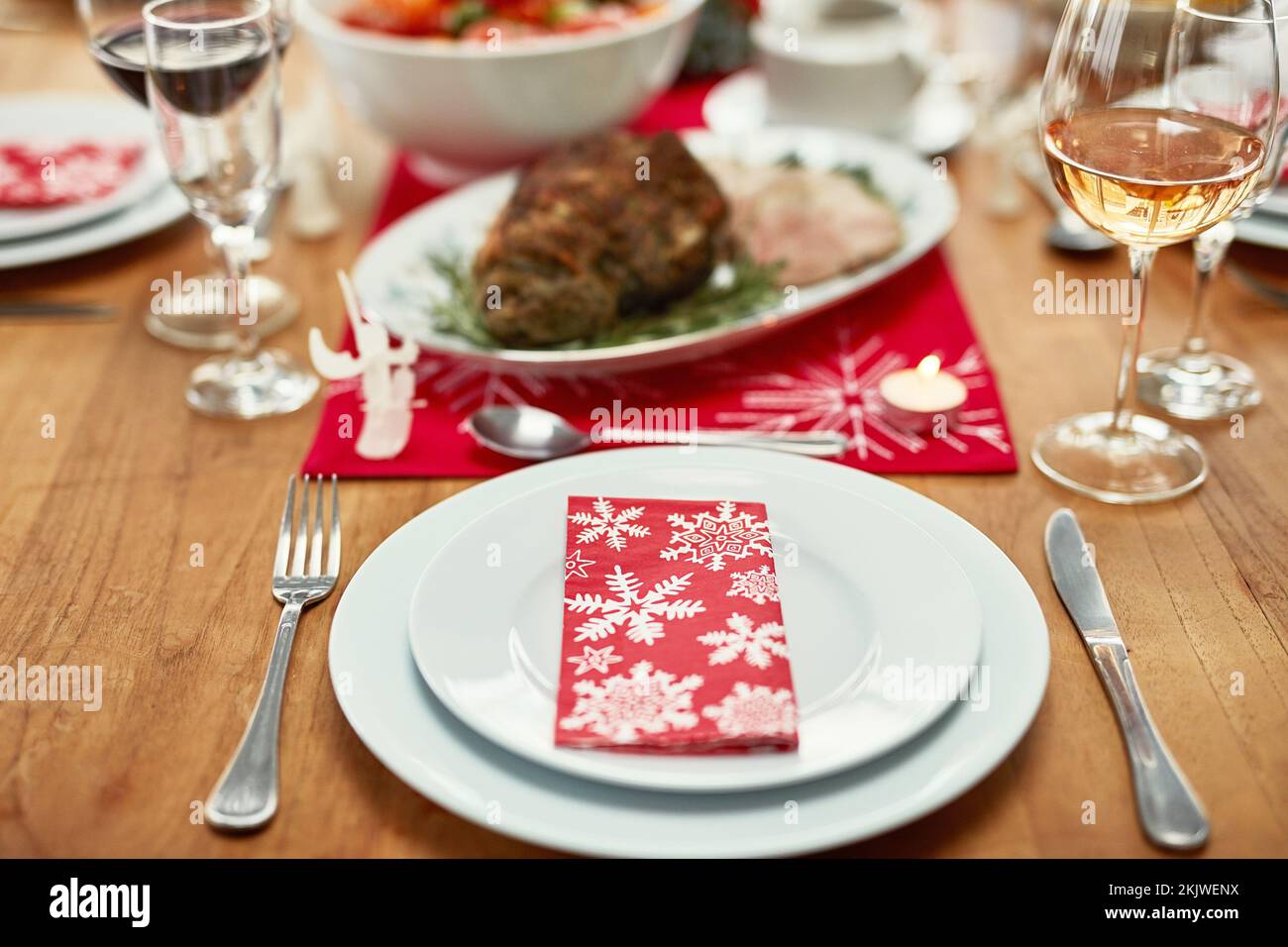 Weinglas, Teller und Besteck auf dem Tisch bei einer weihnachtsfeier oder -Veranstaltung im Speisesaal eines Hauses. Serviette, Tischaufstellung und Dinnerparty für eine Stockfoto