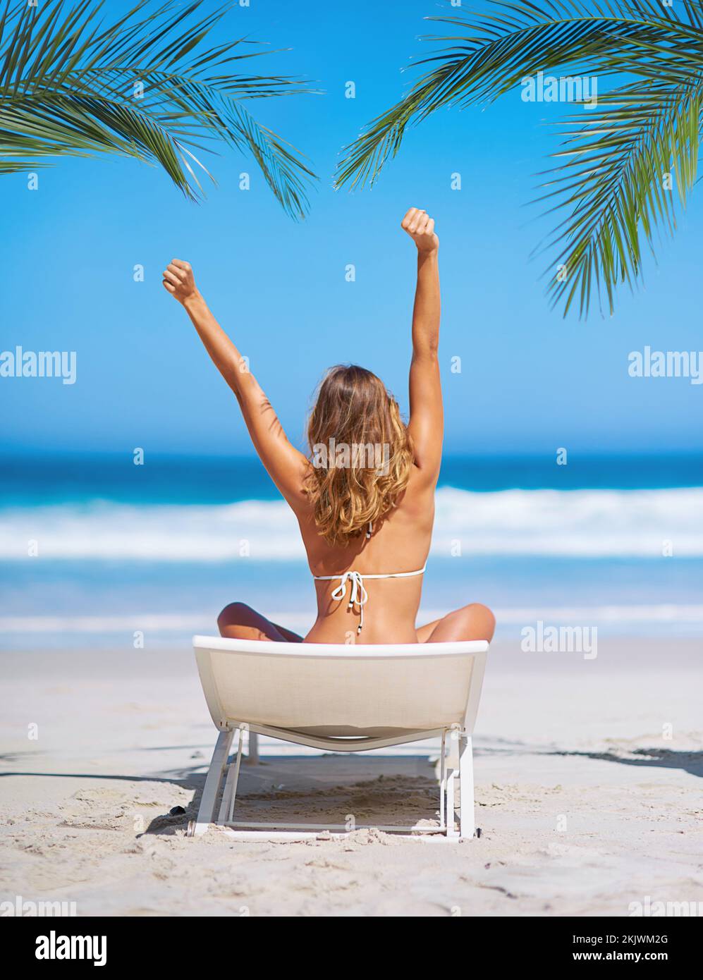 Strand, Entspannung und Blick auf die Frau auf einem Stuhl im Urlaub, Urlaub oder Sommer. Freiheit, Frieden oder junge Frau im Bikini, die sich an der Küste streckt Stockfoto