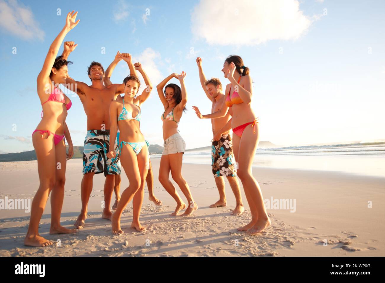 Fröhliche Teenager, die am Strand tanzten. Porträt von glücklichen Teenagern, die am Strand tanzen. Stockfoto
