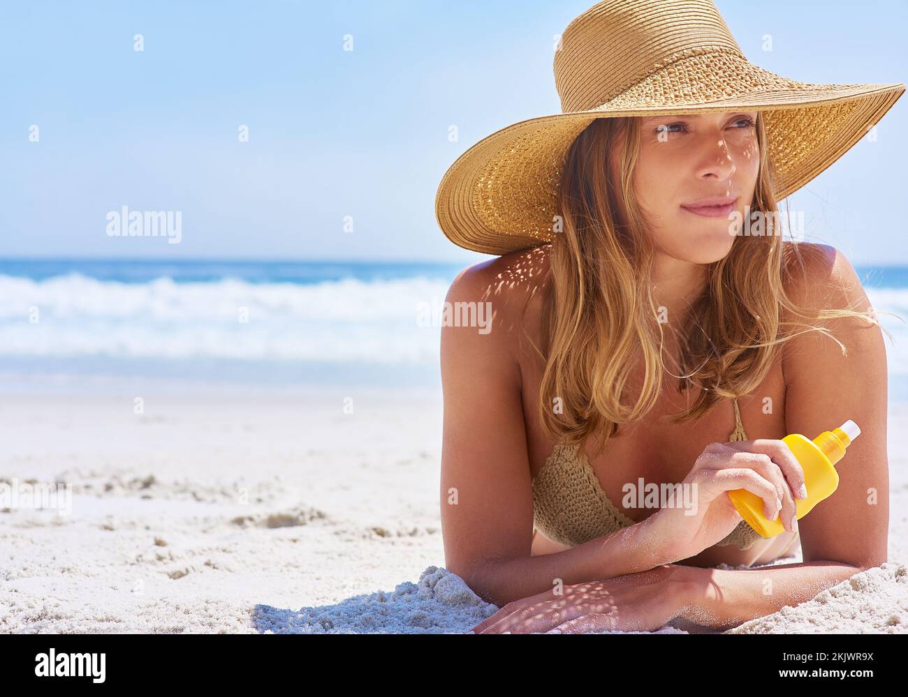 Frau, Strand und Sonnencreme während eines Tropenurlaubs in Bali zum Ausruhen und Entspannen. Hautpflege, Schutz und Sonnencreme mit einer weiblichen Touristin auf einer Stockfoto