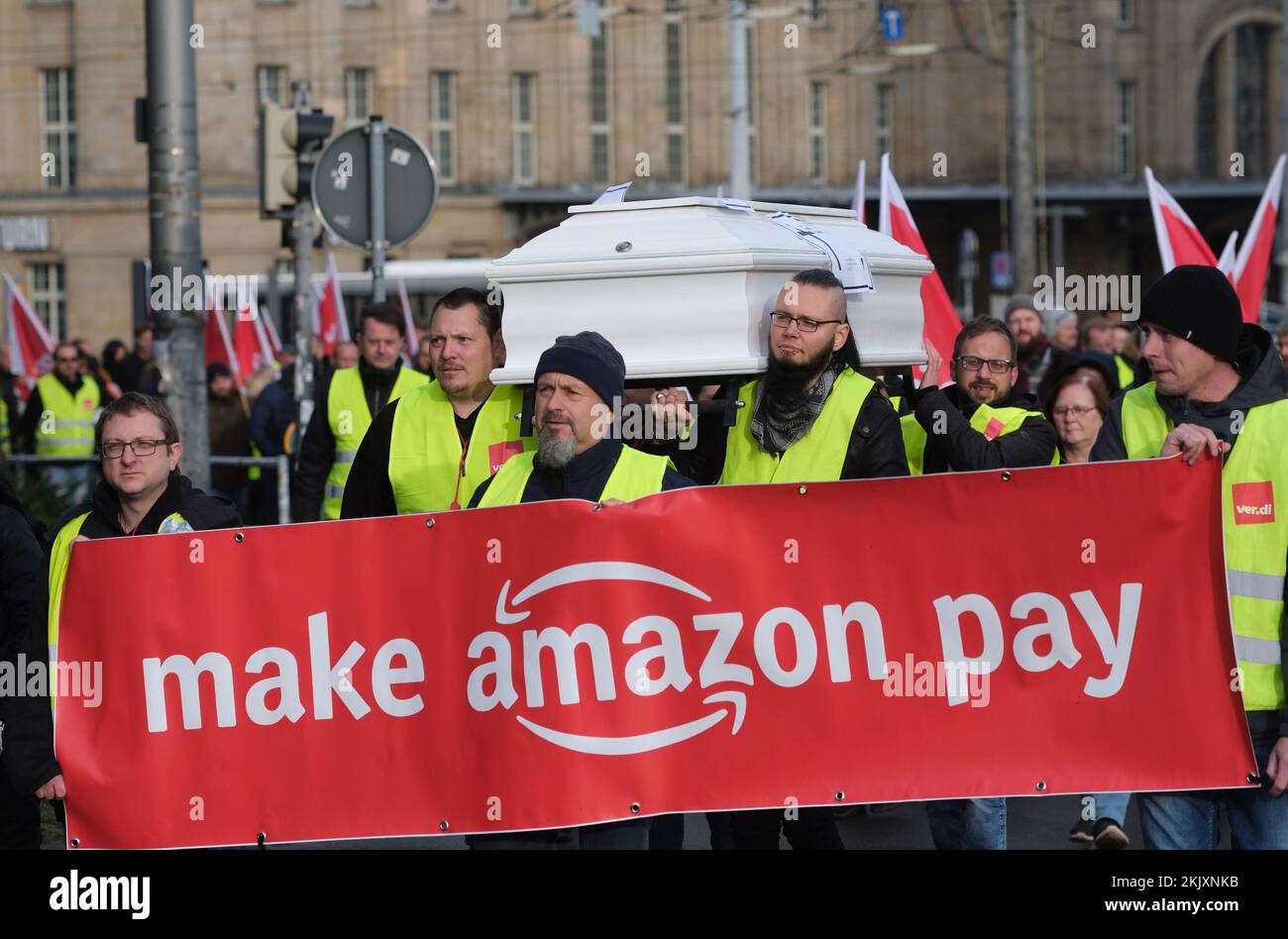 Leipzig, Deutschland. 25.. November 2022. Die Teilnehmer einer Demonstration der Gewerkschaft Verdi gehen mit Flaggen und tragen ein Banner mit der Aufschrift „Make Amazon Pay“ und einen Sarg. Rund 200 Mitarbeiter des Online-Versandunternehmens Amazon protestierten für bessere Arbeitsbedingungen und angemessene Bezahlung. Kredit: Sebastian Willnow/dpa/Alamy Live News Stockfoto