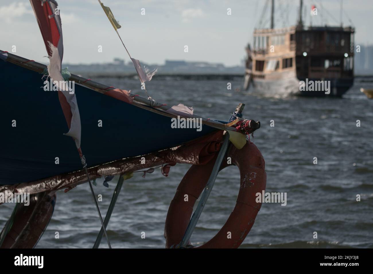 Ein Schiff überquert ein Holzschiff auf dem offenen Wasser Stockfoto