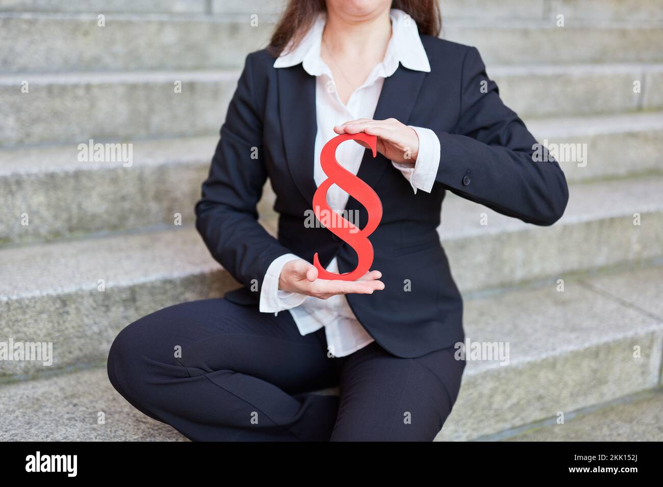 Geschäftsfrau mit rotem Absatzschild als Symbol für Recht und Gerechtigkeit Stockfoto