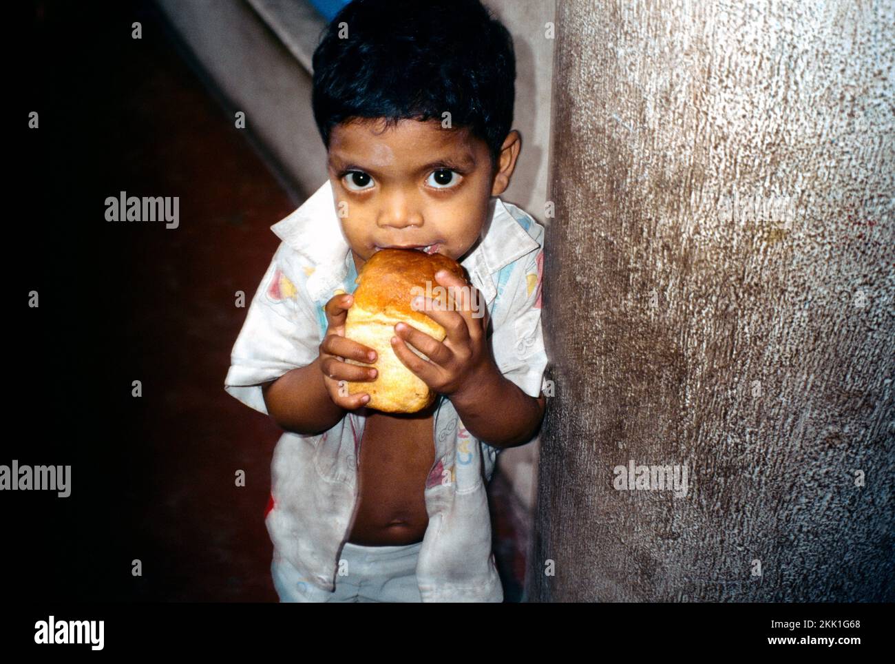 Kolkata (Kalkutta) Indien Unterernährtes Kind, Das Brot An Der Jack Pregers Schulklinik Für Bedürftige Isst Stockfoto