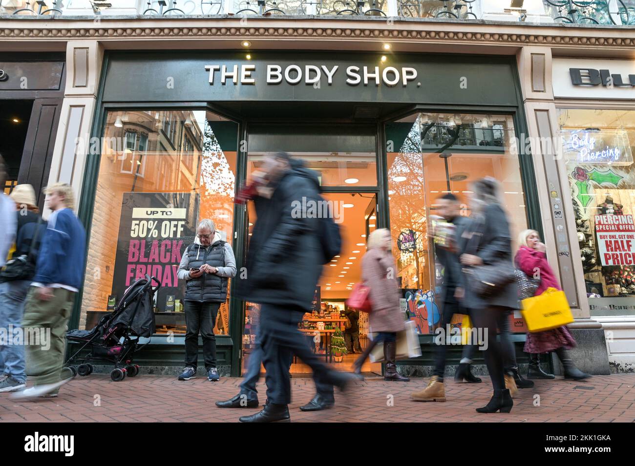 New Street, Birmingham, 25. November 2022. - Ein Mann wartet vor dem Body Shop im Stadtzentrum von Birmingham, während seine Familie am Black Friday die Deals dort ansieht. PIC by Credit: Stop Press MediaAlamy Live News Stockfoto