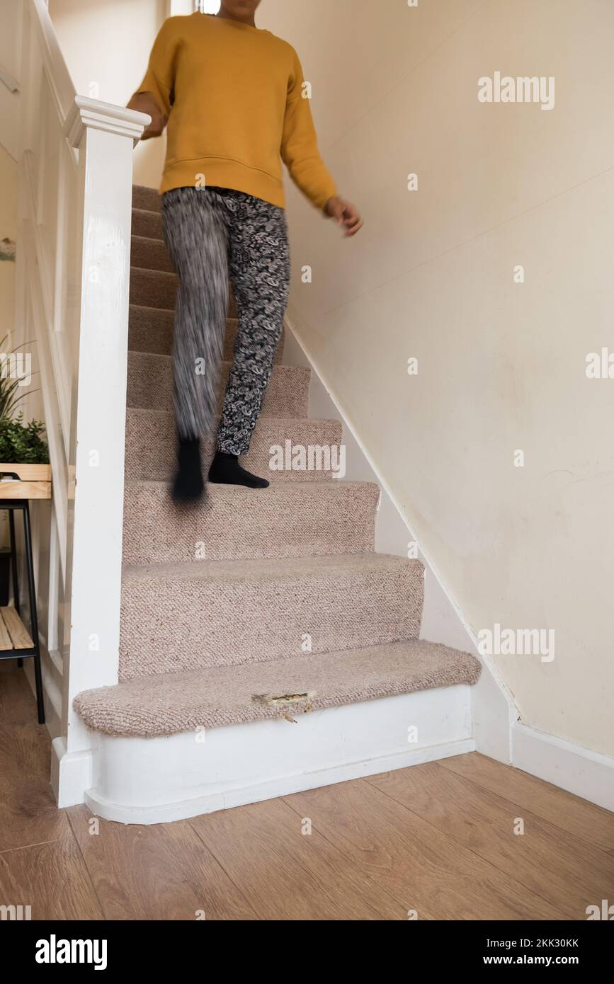 Verletzungsgefahr durch Stolpern oder Ausrutschen auf abgenutzten Teppichen auf Treppen Treppenaufstieg im Miethaus kann zu einem gebrochenen Knöchel oder einem ausgekuppelten Fuß führen Stockfoto