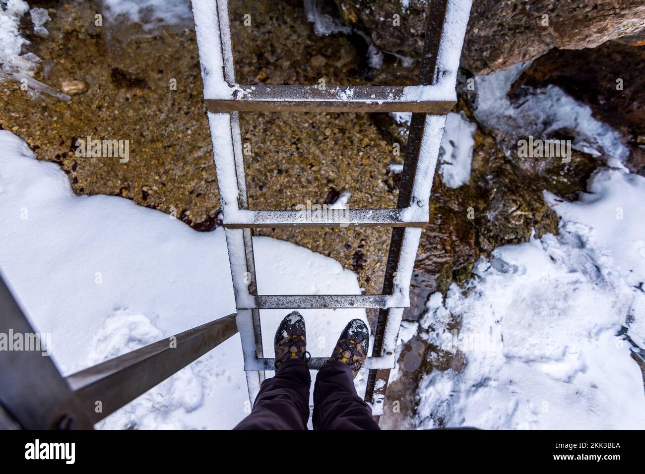 Outdoor-Leiter im Nationalpark Janosikove Diery. Touristenschuhe auf der Leiter. Schnee und Winter. Stockfoto