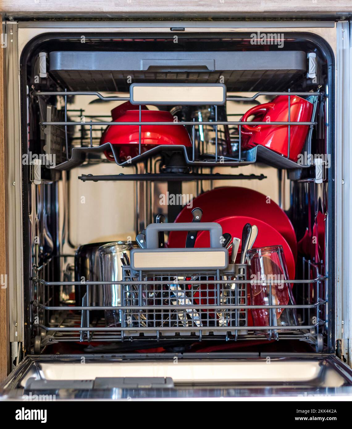 Schauen Sie mit der sauberen Schale in die Spülmaschine. Saubere Platte in Küchenreinigungsmaschine gelegt Stockfoto