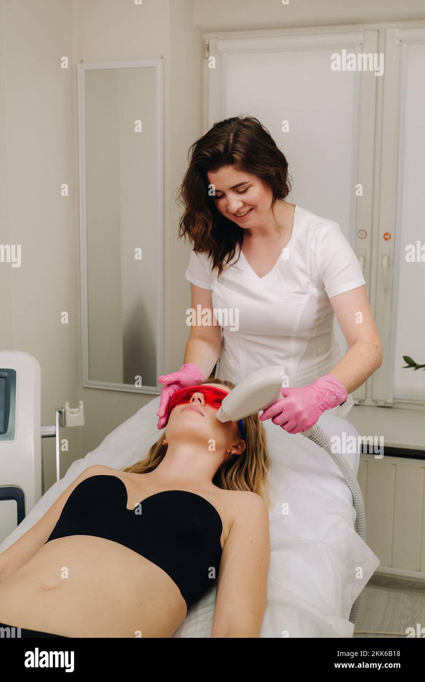 Ein Arzt macht Laserhaarentfernung für einen Kunden mit unerwünschtem Gesichtshaar in einem Schönheitssalon Stockfoto