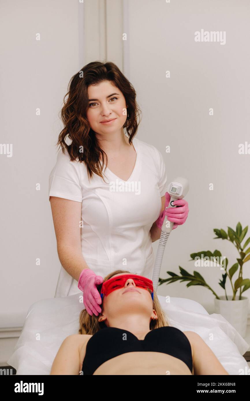 Ein Arzt macht Laserhaarentfernung für einen Kunden mit unerwünschtem Gesichtshaar in einem Schönheitssalon Stockfoto