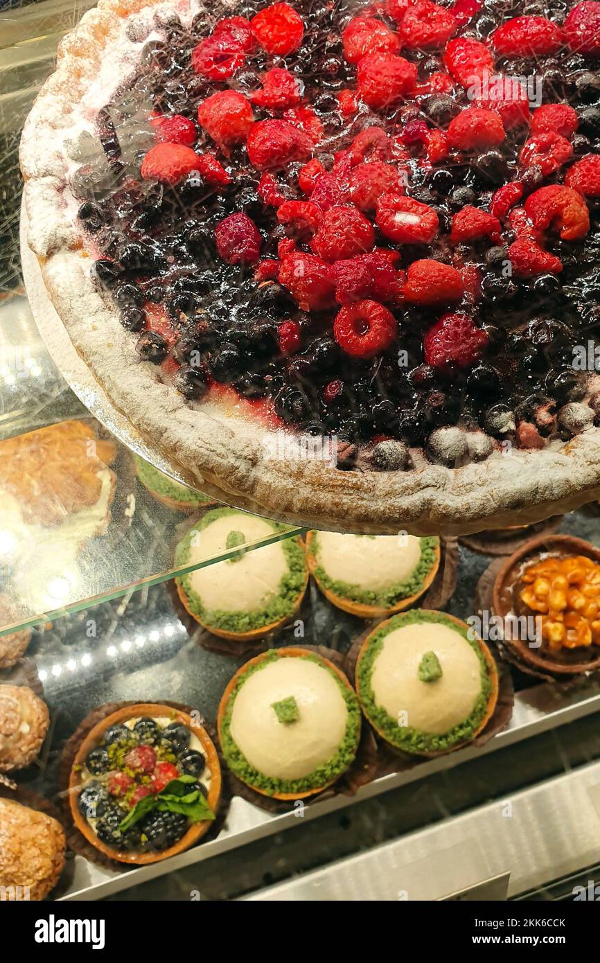Süßwaren mit wilden Beerentorte, Obsttörtchen und Kuchentorte. Draufsicht, vertikales Foto. Stockfoto