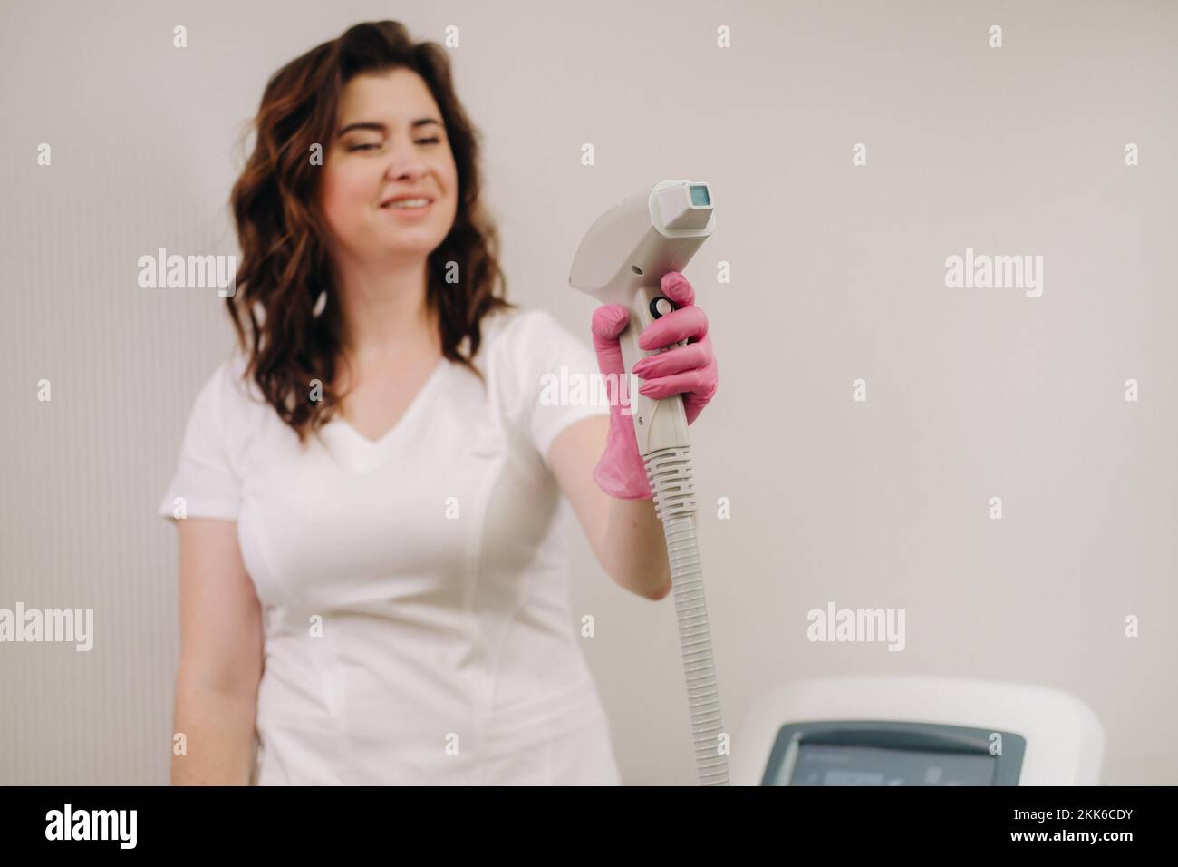 Porträt des Meisters der Laserhaarentfernung. Eine Frau in einem weißen Kittel hält ein Laser-Haarentfernungsgerät in den Händen Stockfoto