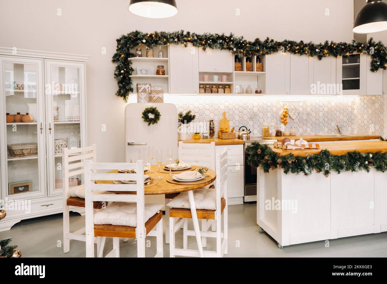 Weihnachtstischdekoration in der Küche, Banketttisch mit Gläsern vor dem Servieren des Essens, Nahaufnahme des Weihnachts-Dinner-Tisches mit saisonalen Stockfoto