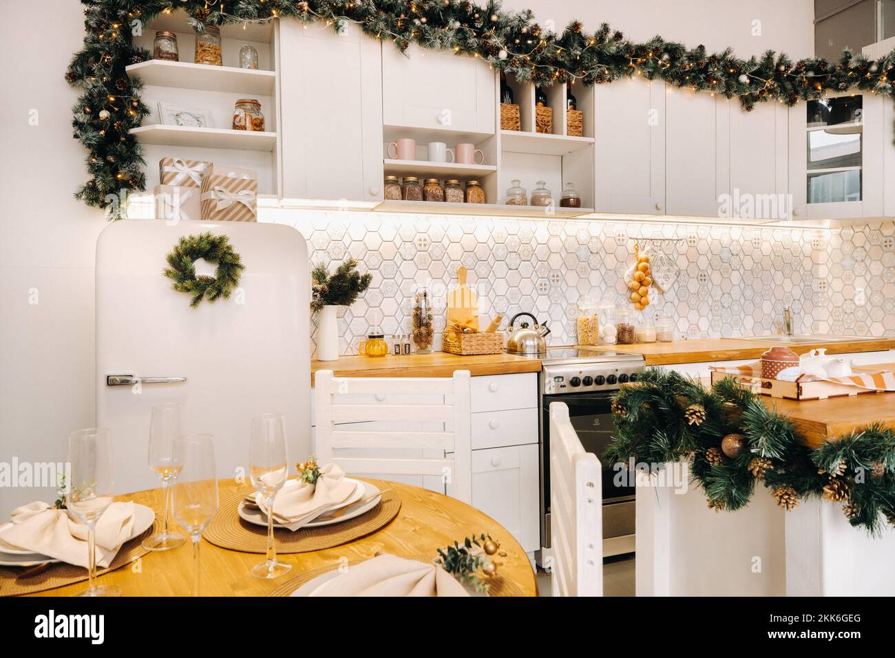 Weihnachtstischdekoration in der Küche, Banketttisch mit Gläsern vor dem Servieren des Essens, Nahaufnahme des Weihnachts-Dinner-Tisches mit saisonalen Stockfoto