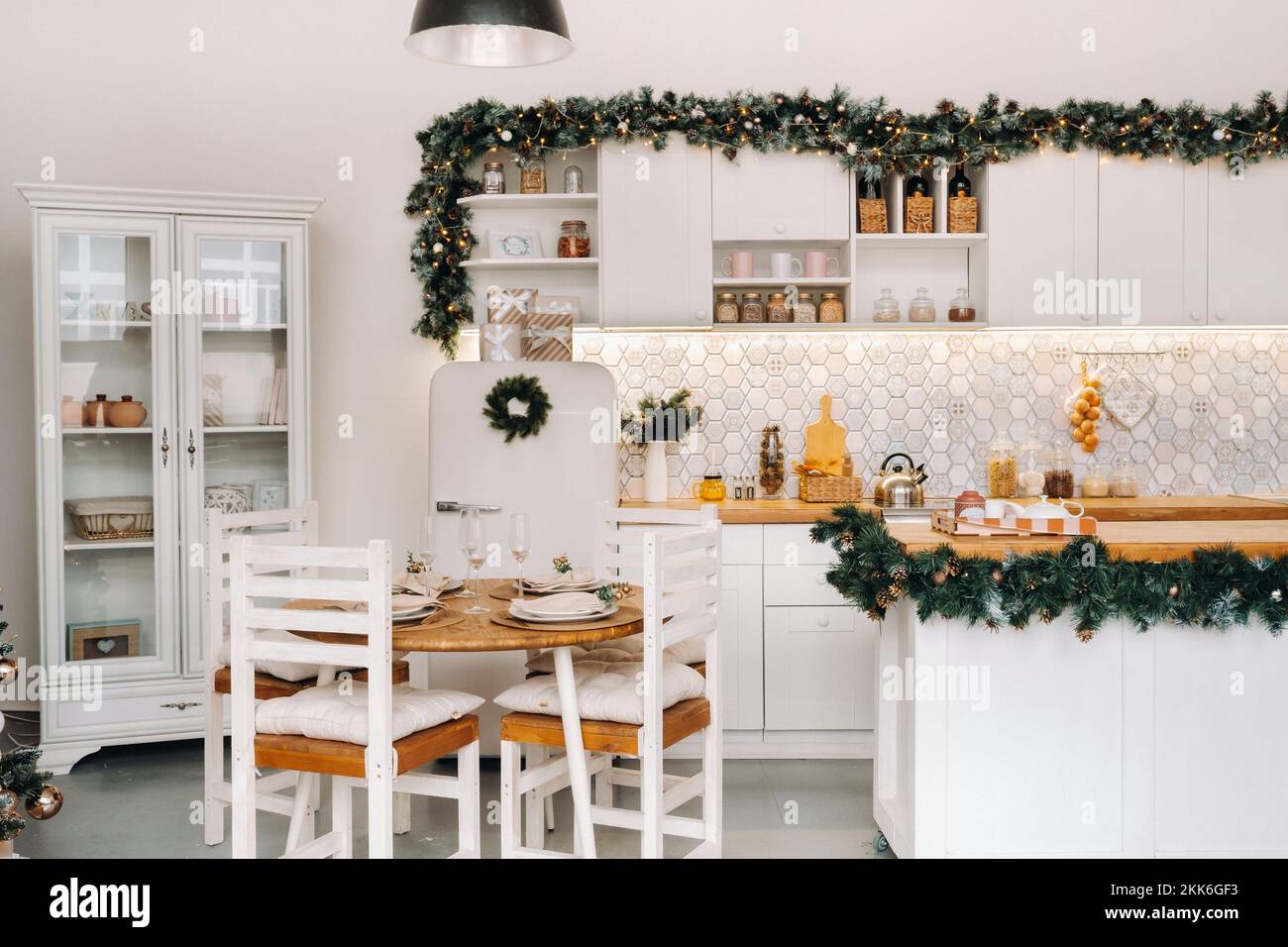 Weihnachtstischdekoration in der Küche, Banketttisch mit Gläsern vor dem Servieren des Essens, Nahaufnahme des Weihnachts-Dinner-Tisches mit saisonalen Stockfoto