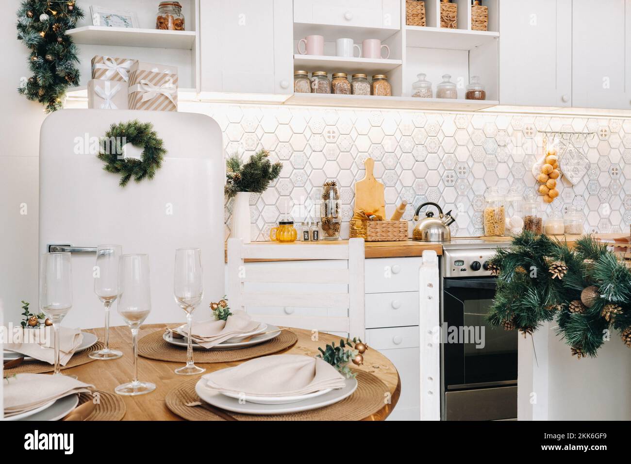 Weihnachtstischdekoration in der Küche, Banketttisch mit Gläsern vor dem Servieren des Essens, Nahaufnahme des Weihnachts-Dinner-Tisches mit saisonalen Stockfoto